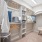 large walk-in closet with built-in shelving and a chair